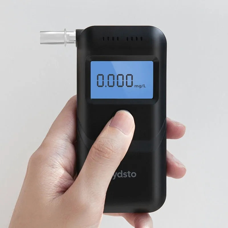 Black portable digital alcohol breath tester with display on a white background.