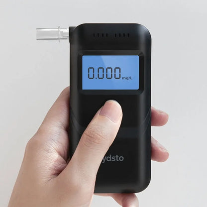 Black portable digital alcohol breath tester with display on a white background.