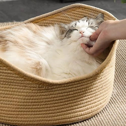 Wicker-style cat bed basket with integrated corrugated cardboard scratching surface, shown in a home setting.