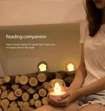 Grey cat paw-shaped night light with USB port, sitting on a surface, demonstrating its soft glow and cute design.