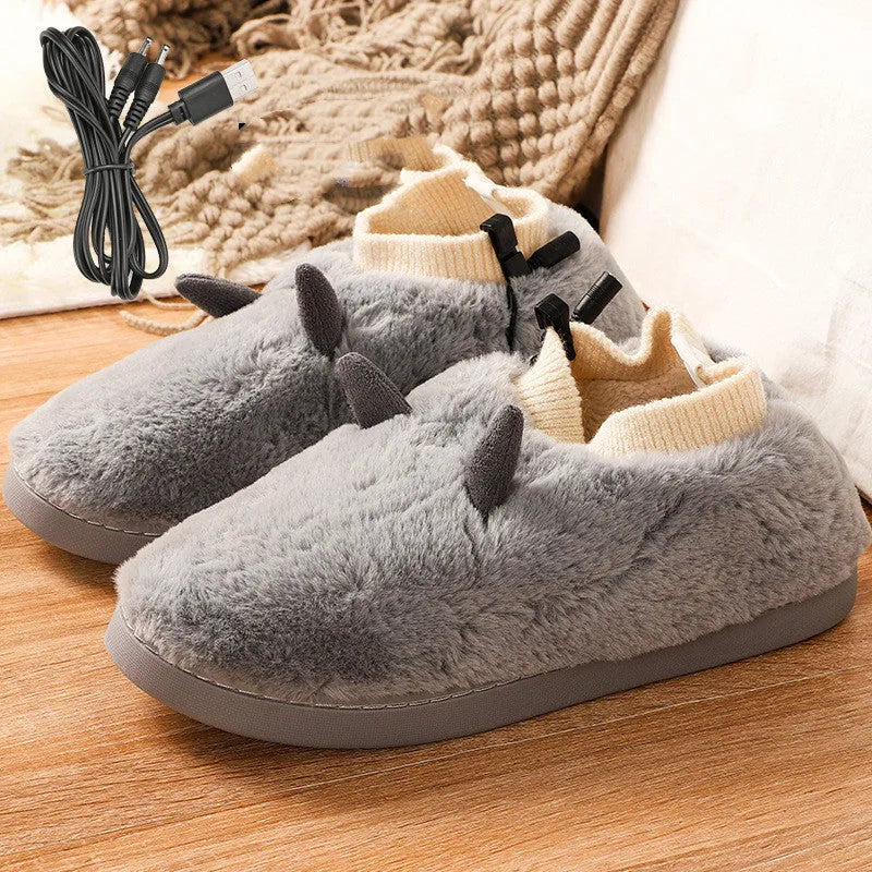 USB heating slippers in black plugged into a laptop, showing the cable and soft velvet upper.