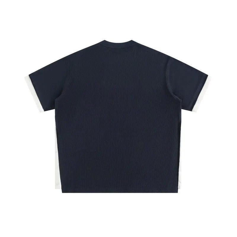 Loose fit waffle fabric T-shirt with retro alphabet embroidery on the chest, shown in navy blue.