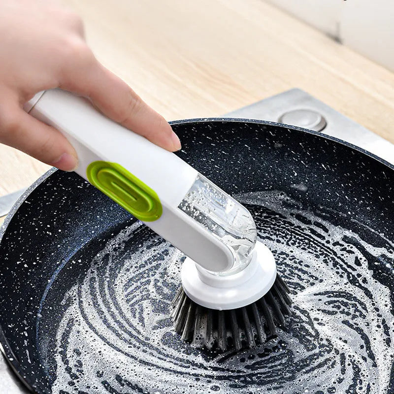 White and red long-handle kitchen brush with soap dispenser button and two interchangeable scrub heads on a hook.