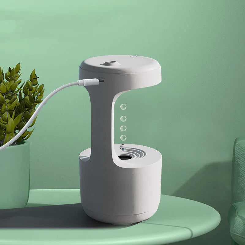 White columnar anti-gravity humidifier with water droplet backflow and LED clock display on a desk.