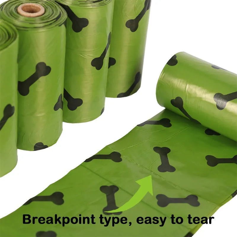 Roll of military green degradable dog poop bags with black bone print, shown next to a plastic dispenser.