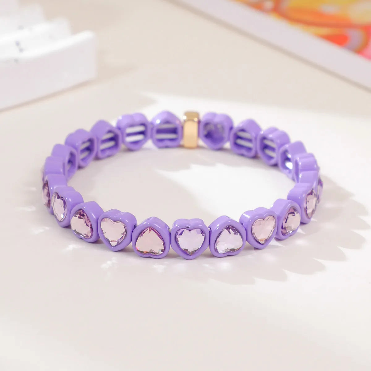 Colourful enamel heart shape on a silver-toned alloy stretch bracelet.