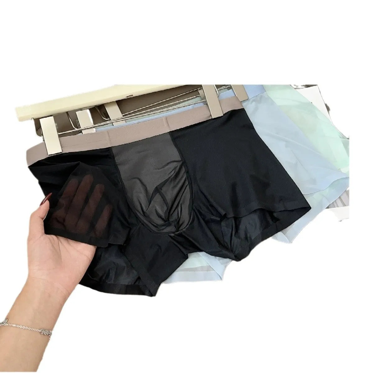 Ultra-thin seamless men's boxers in black with a honeycomb crotch design, laid flat.