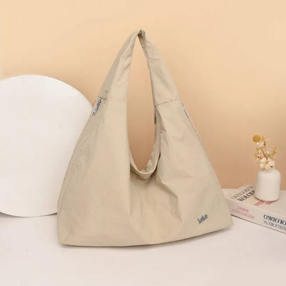 A soft nylon underarm bag with a heart-shaped design in blue, shown worn crossbody.