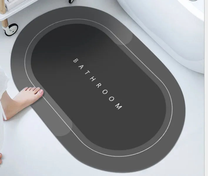 Oval diatomite bathroom floor mat in blue with natural rubber non-slip backing on tiled floor.