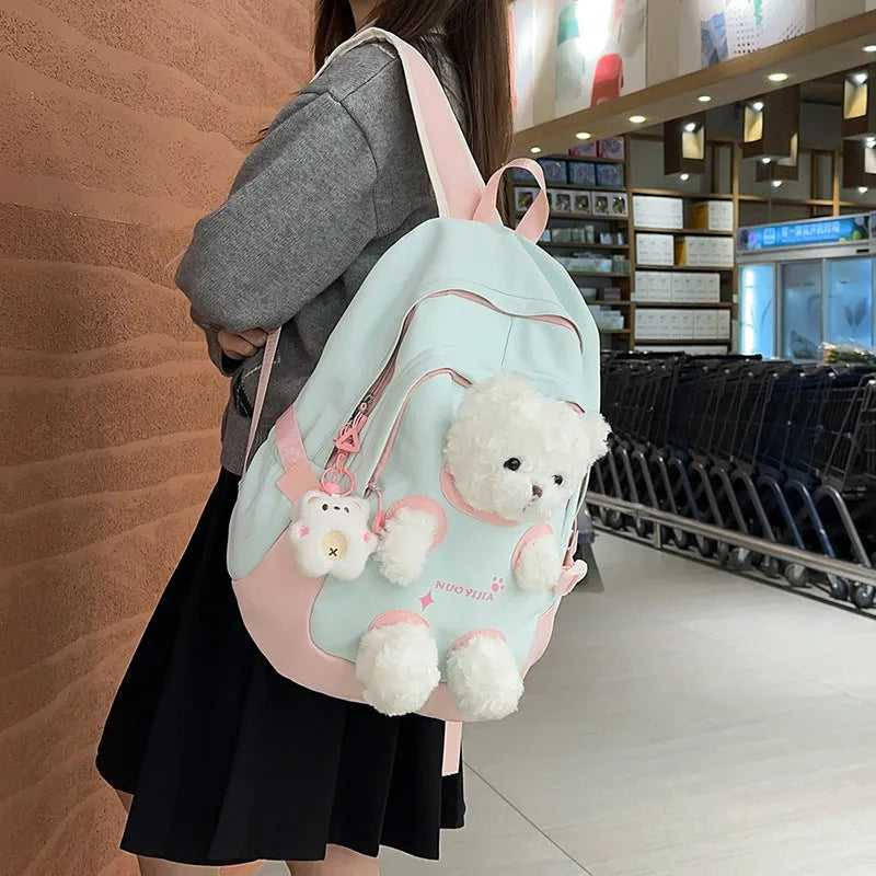 Macaron colour nylon school backpack with curved straps, shown in yellow pink, with a pendant attached.