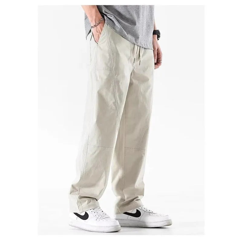 Beige cotton wide-leg trousers with an elasticated waistband laid flat.