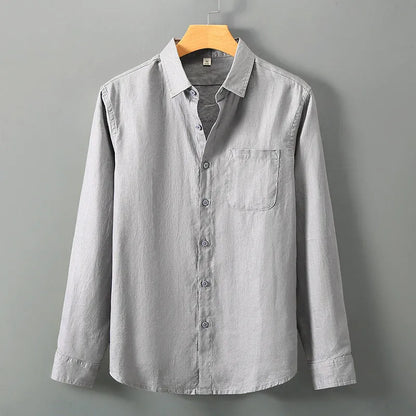Man wearing a loose-fit light grey long sleeve linen cardigan shirt with a Chinese style design.