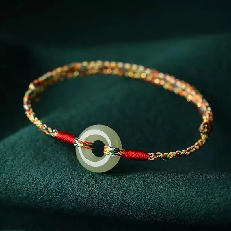 Colourful woven rope bracelet with silver peace buckle fastening on wrist