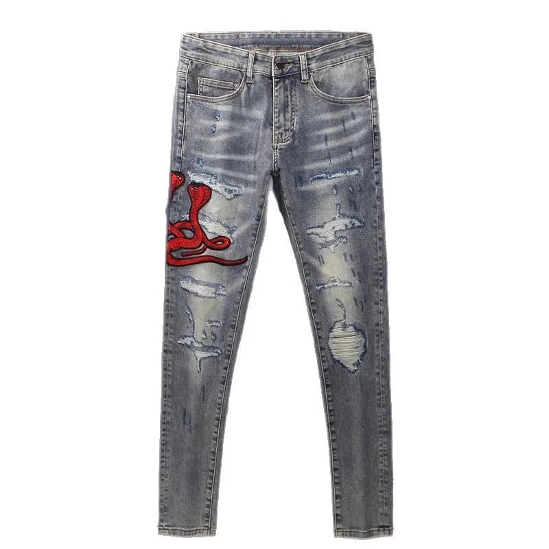 Men's slim fit cotton jeans with washed-out finish, hole patch detailing, and embroidery in old colour
