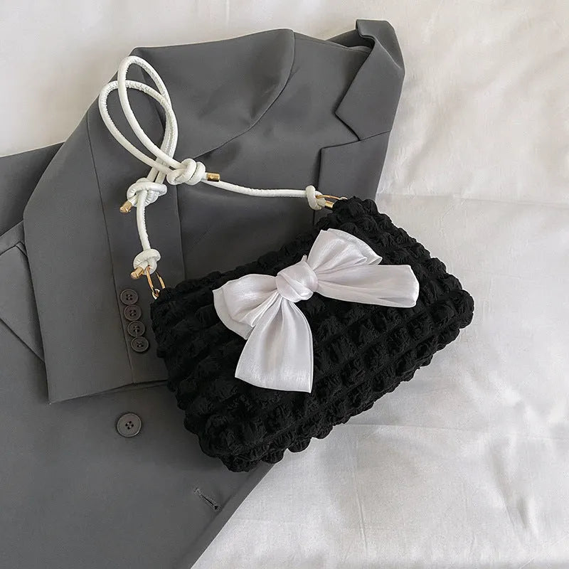 Women's black canvas single shoulder handbag with a sandwich pocket and horizontal square shape.
