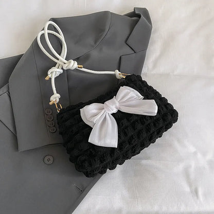 Women's black canvas single shoulder handbag with a sandwich pocket and horizontal square shape.