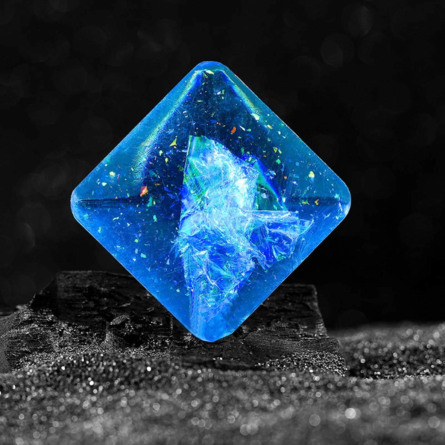 Galactic edition pocket gyro desk toy on a surface, showing its quadrilateral resin construction and celestial colour design.