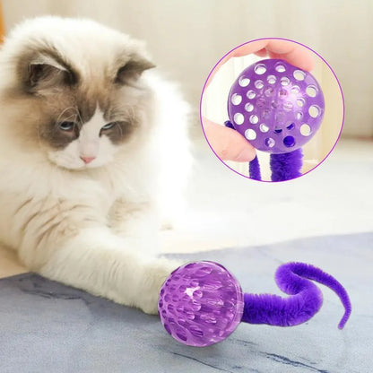 Green interactive cat toy with a bouncy ball and a long worm-shaped tail on a plain background.