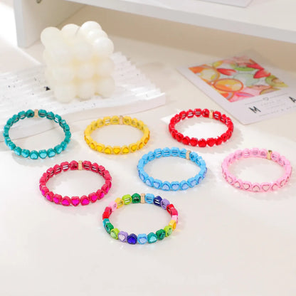 Colourful enamel heart shape on a silver-toned alloy stretch bracelet.