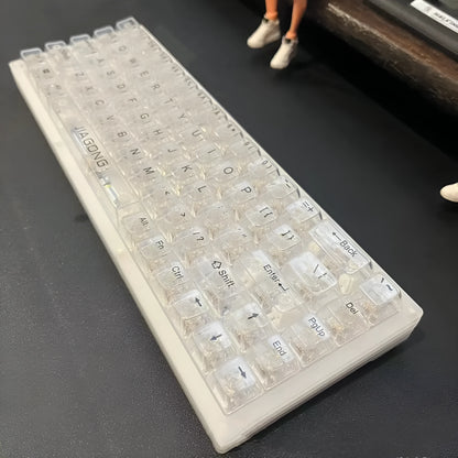 Full set of 132 transparent plastic keycaps for mechanical keyboard customisation on a white background.