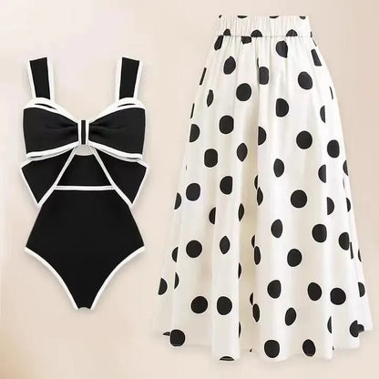 Women's black one-piece swimsuit with white attached round skirt and decorative bow at front