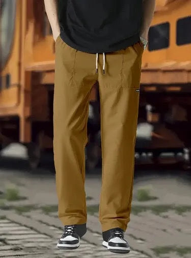 Men's light grey polyester trousers with an elasticated waistband laid flat