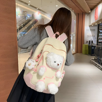 Macaron colour nylon school backpack with curved straps, shown in yellow pink, with a pendant attached.