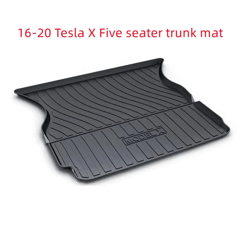 Custom black rubber floor mats fitted in a Tesla Model 3, showing deep grooves and raised edges.