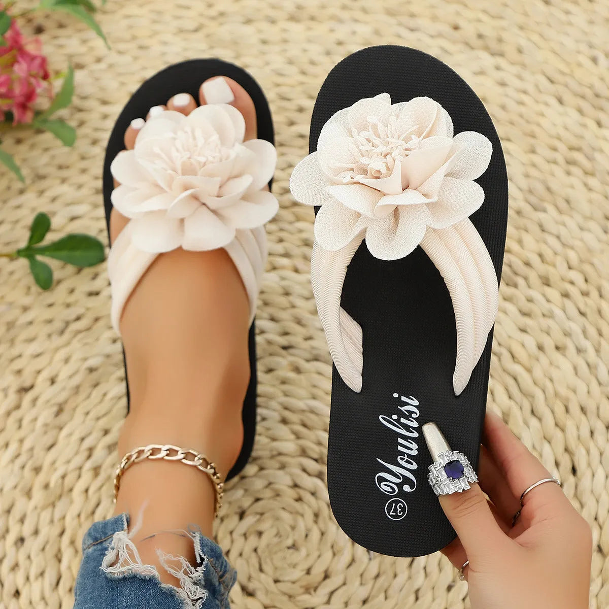 Solid-colour flower flip flops with a decorative floral detail on a viscose upper and EVA sole.