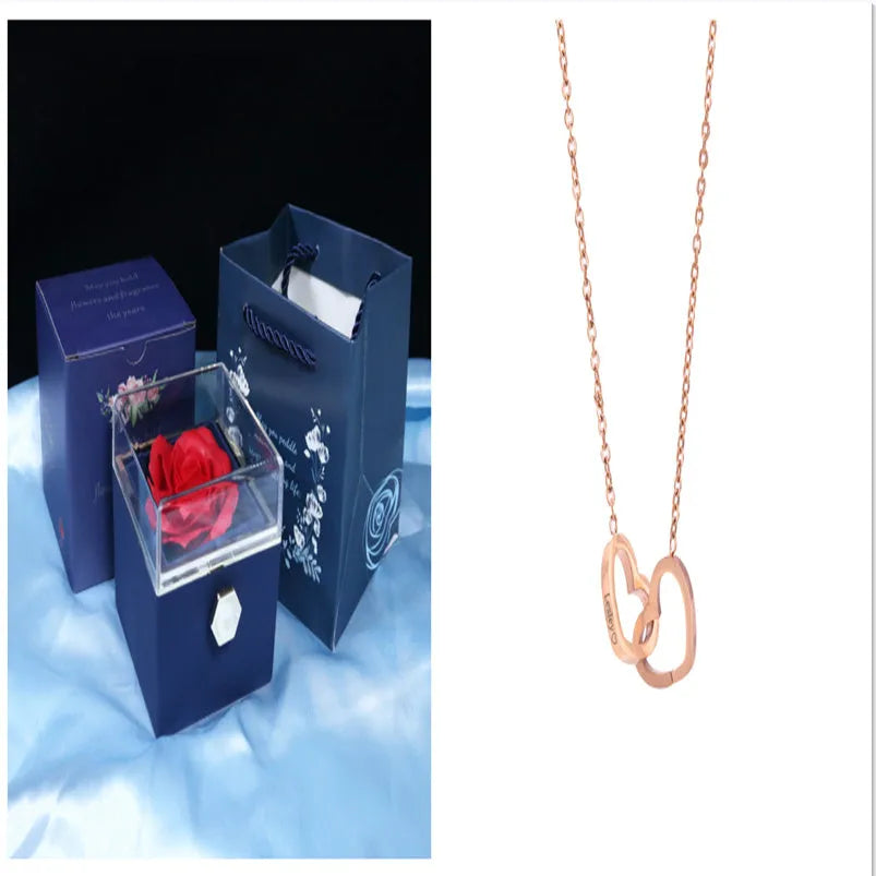 Rotating rose jewellery gift box with a preserved red rose under a clear acrylic dome, showing the interior rotating drawer.