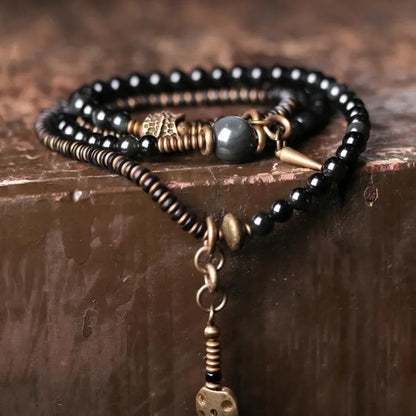 Black geometric beaded bracelet with multi-layered colourful design on wrist