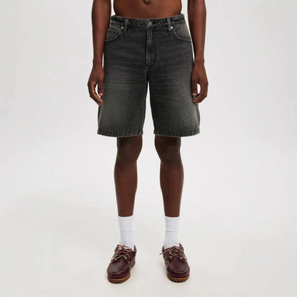 Men's light blue loose straight-leg cotton jeans laid flat, showing the front design and fifth-pants length.