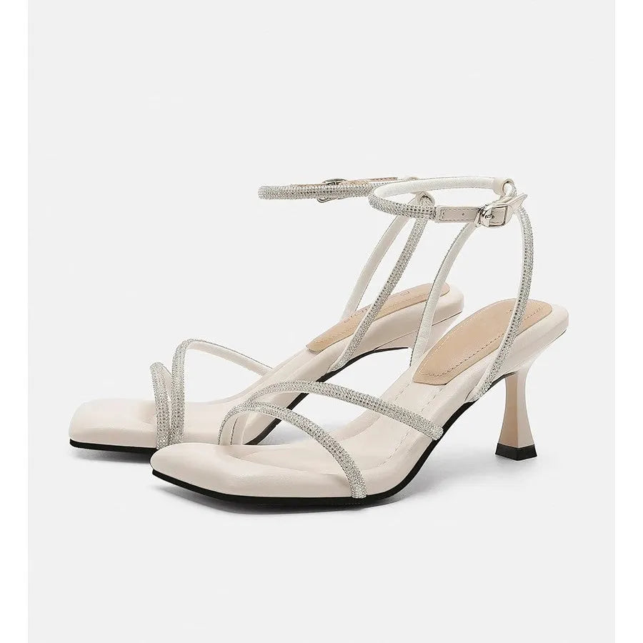 Women's silver rhinestone sandals with square toe and ankle strap buckle on a white background.
