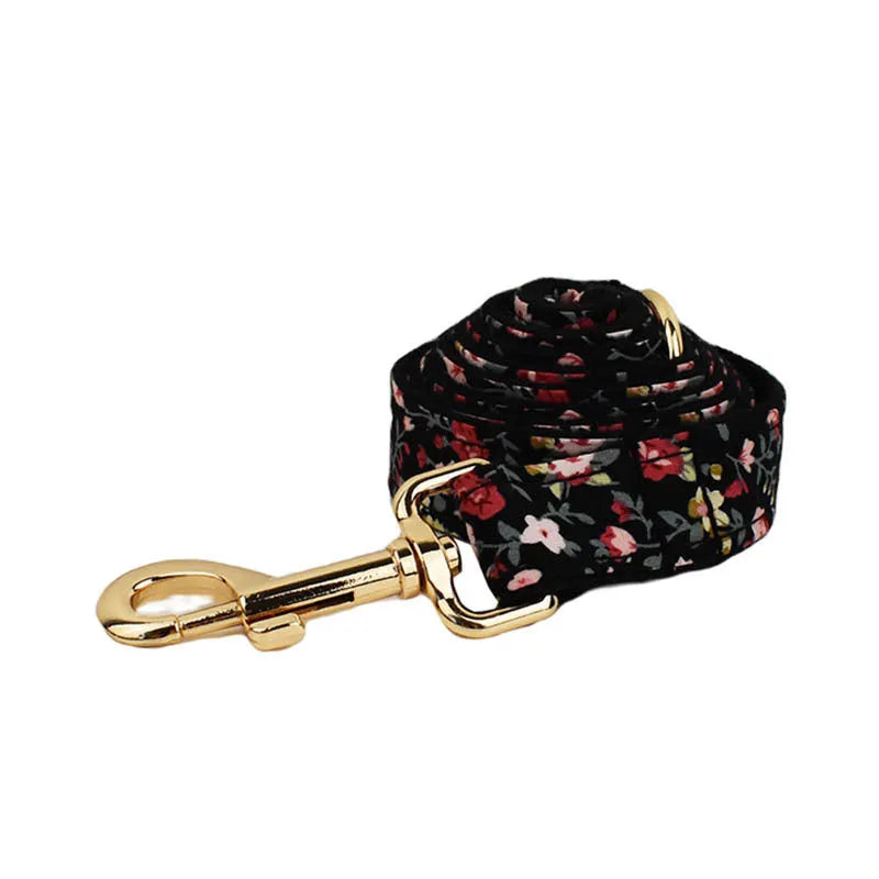 Four-piece dog accessory set showing a cloth collar, leash, vest, and removable bow with printed lettering.