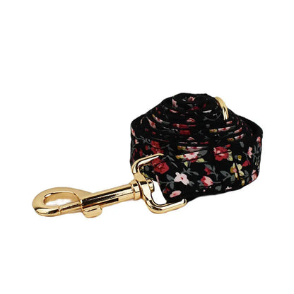 Four-piece dog accessory set showing a cloth collar, leash, vest, and removable bow with printed lettering.