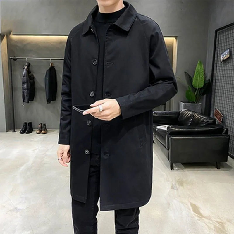 Man wearing a khaki coloured loose fit mid-length trench coat made from rabbit fur fabric.