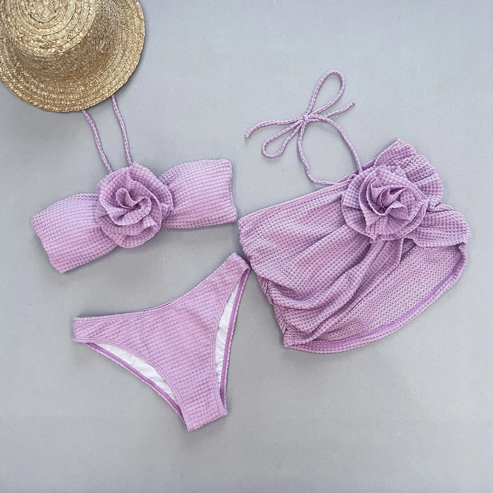 White women's three-piece bikini with 3D floral appliqué on the briefs and a matching lace skirt.