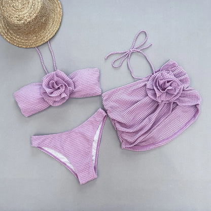 White women's three-piece bikini with 3D floral appliqué on the briefs and a matching lace skirt.