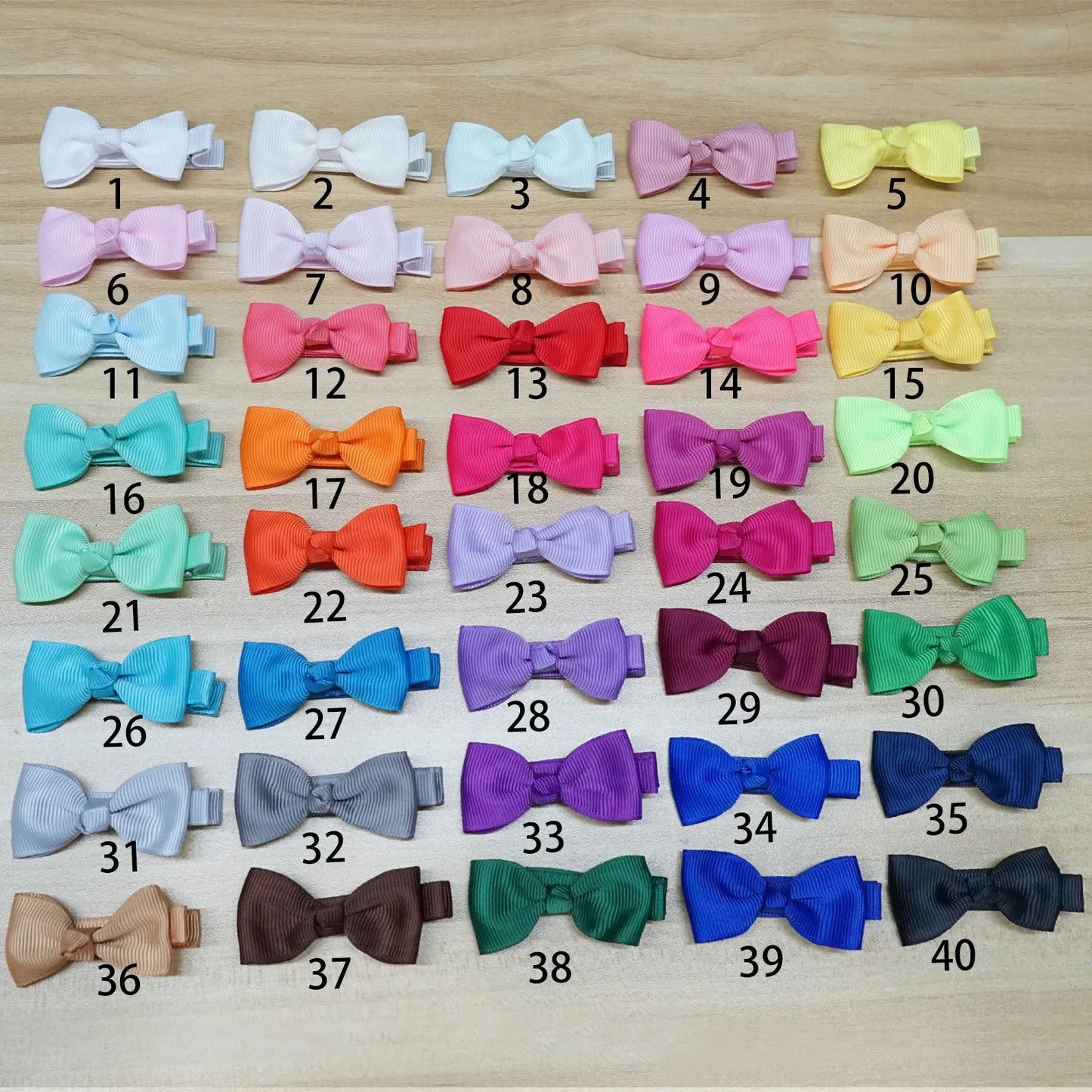 Assortment of pastel-coloured baby hair clips and bows with no-slip grips on a white background.