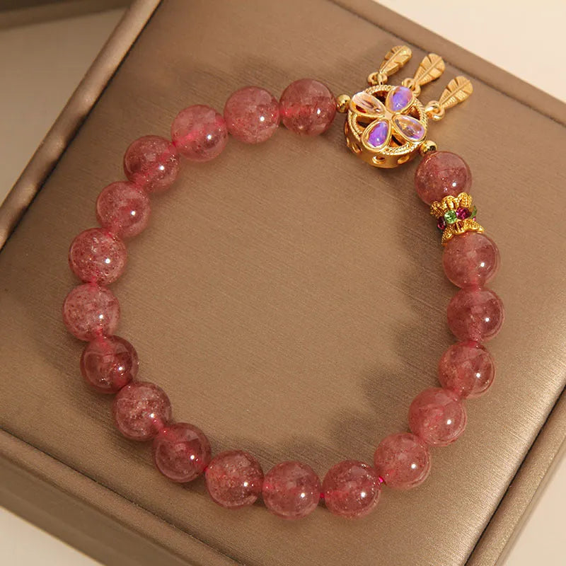 Women's strawberry quartz crystal bracelet with a four-leaf clover dream catcher pendant.