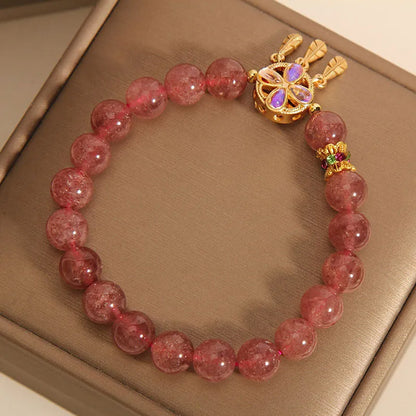 Women's strawberry quartz crystal bracelet with a four-leaf clover dream catcher pendant.