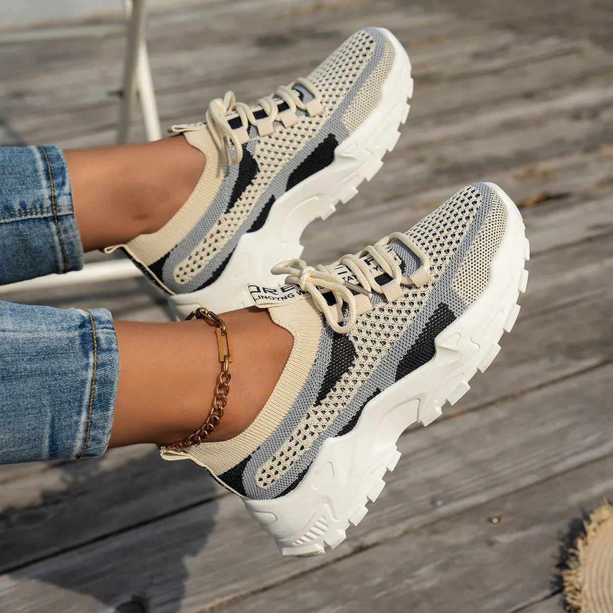 Women's Flyknit mesh lace-up sneaker in a grey colourway showing round toe and rubber sole.