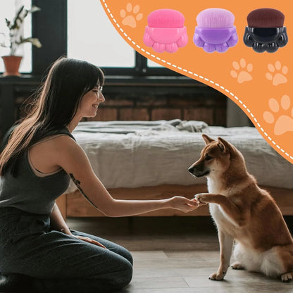 Three small paw-shaped pet balm brushes with soft heads inside clear plastic storage cases.