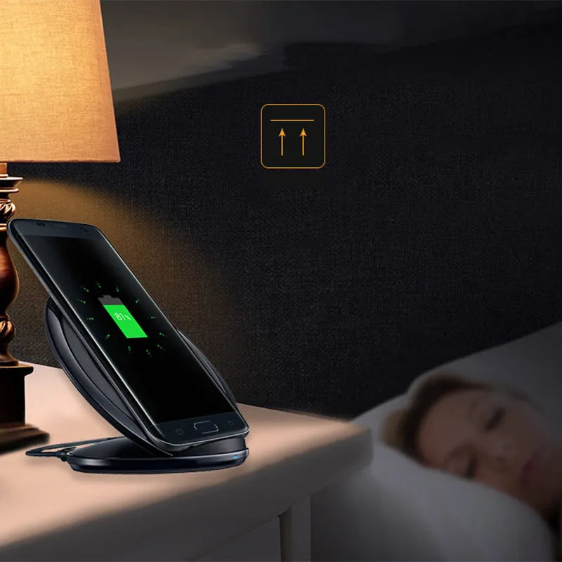 Black Qi wireless charging pad for Samsung Galaxy Note Edge on a desk.