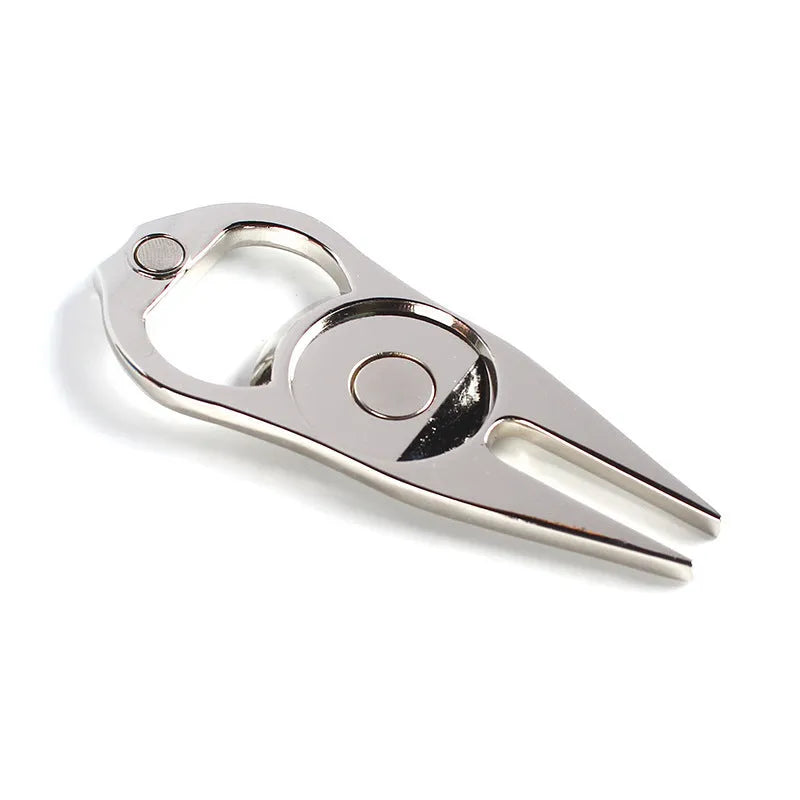 Black zinc alloy golf ball fork and bottle opener tool on a putting green.