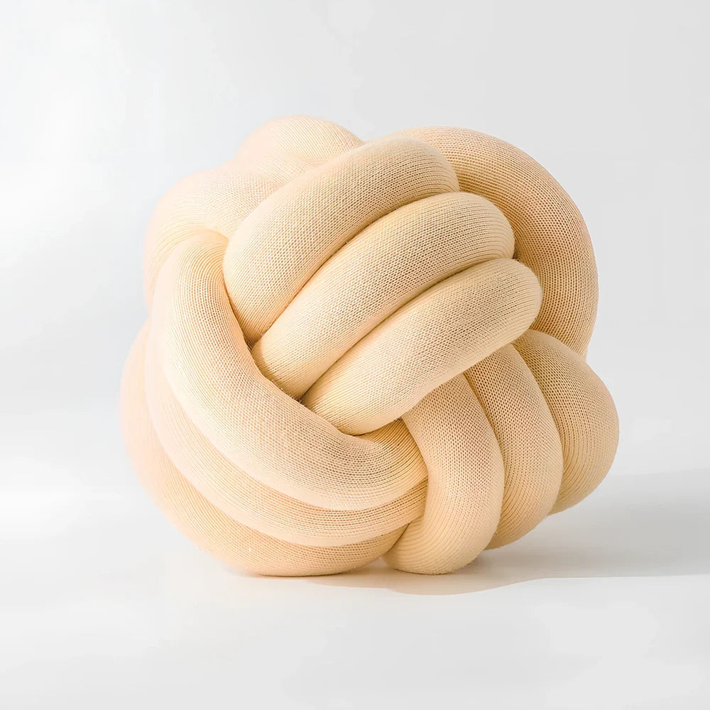 Knotted lumbar pillow with memory foam fill showing adjustable height feature and polyester cover
