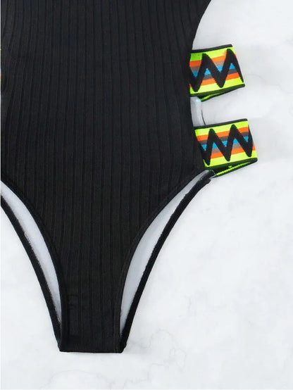 Women's one-piece swimming suit bikini in solid black or orange, made from polyester fabric, showing front view