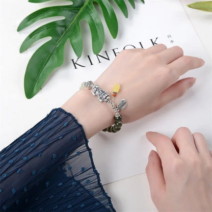 Close-up of a retro-style sterling silver coin bracelet with natural Hetian jade beads for women.