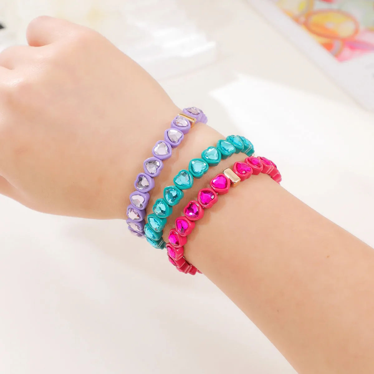 Colourful enamel heart shape on a silver-toned alloy stretch bracelet.