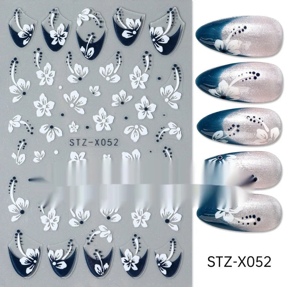 Assortment of black and silver nail sticker designs including cartoon and French tip patterns on a plastic sheet.